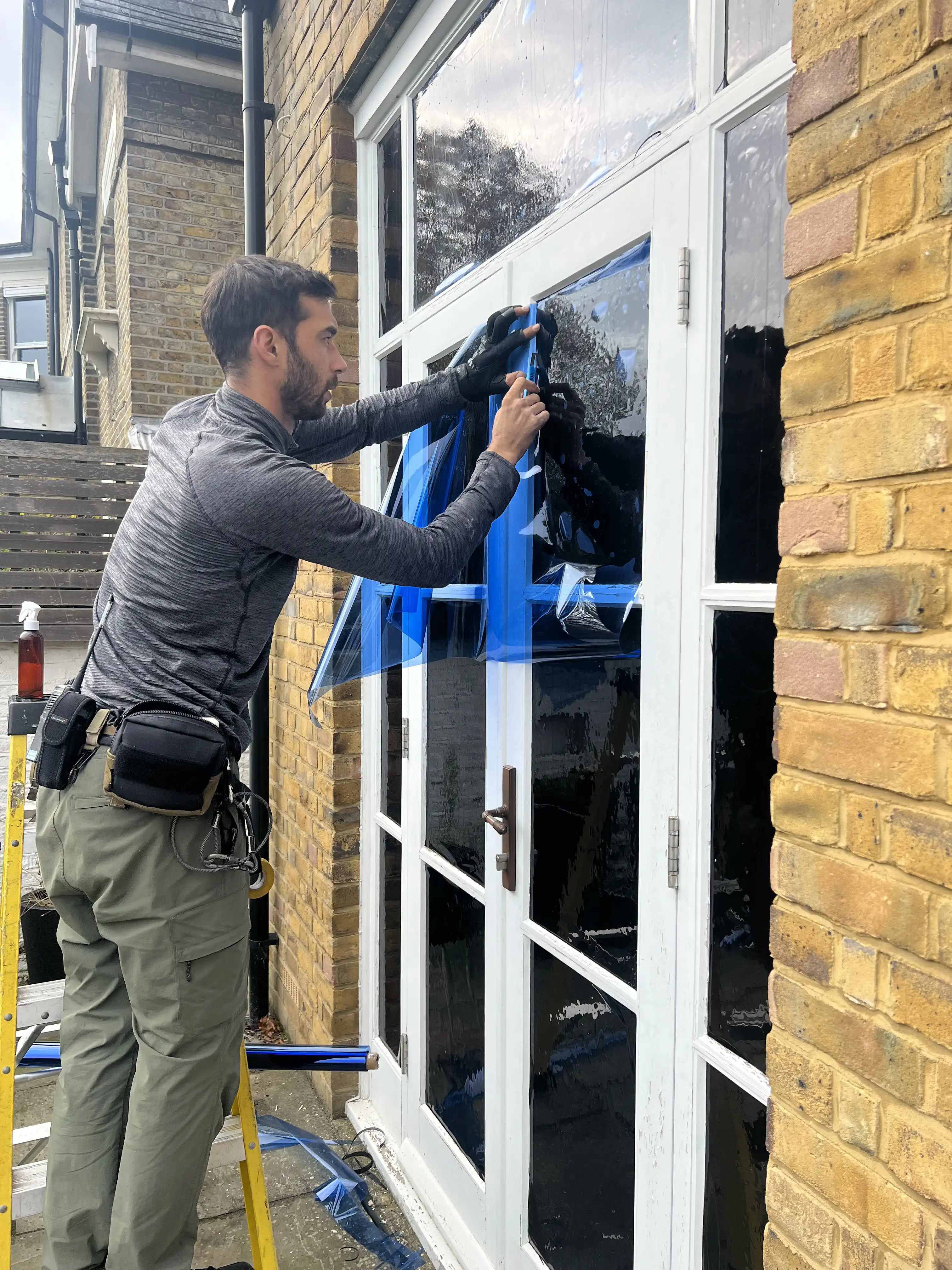 A lighting technician working to gel windows